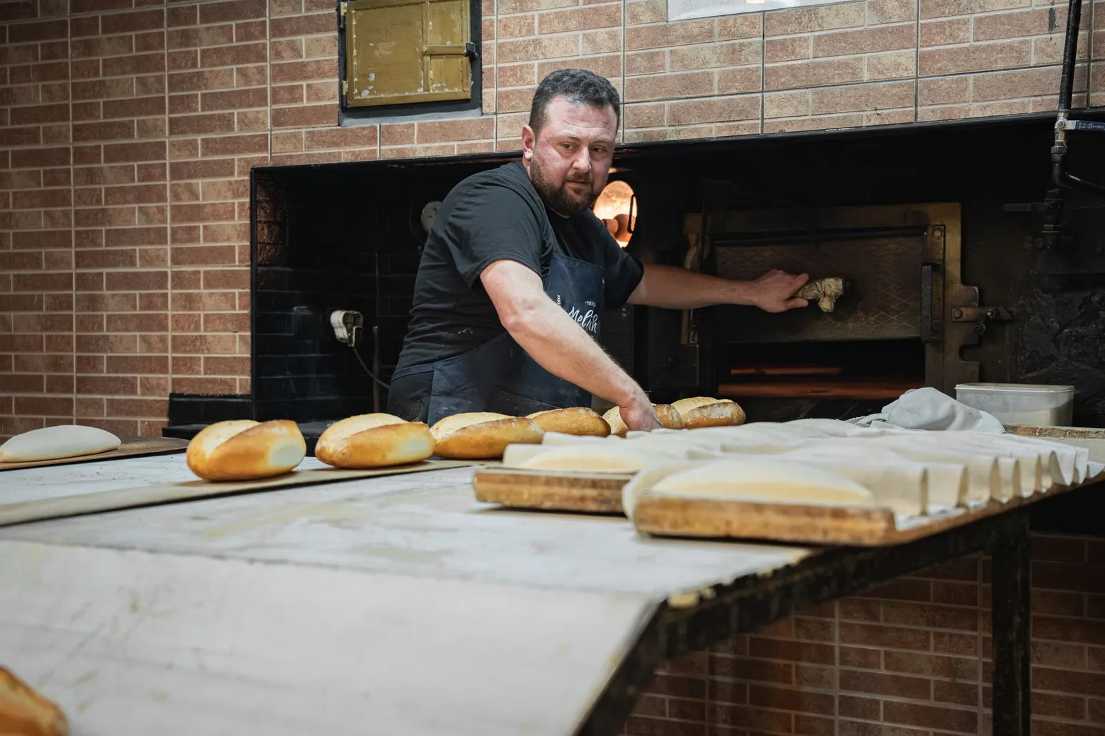 Artisan boulanger enfournant le pain frais du jour