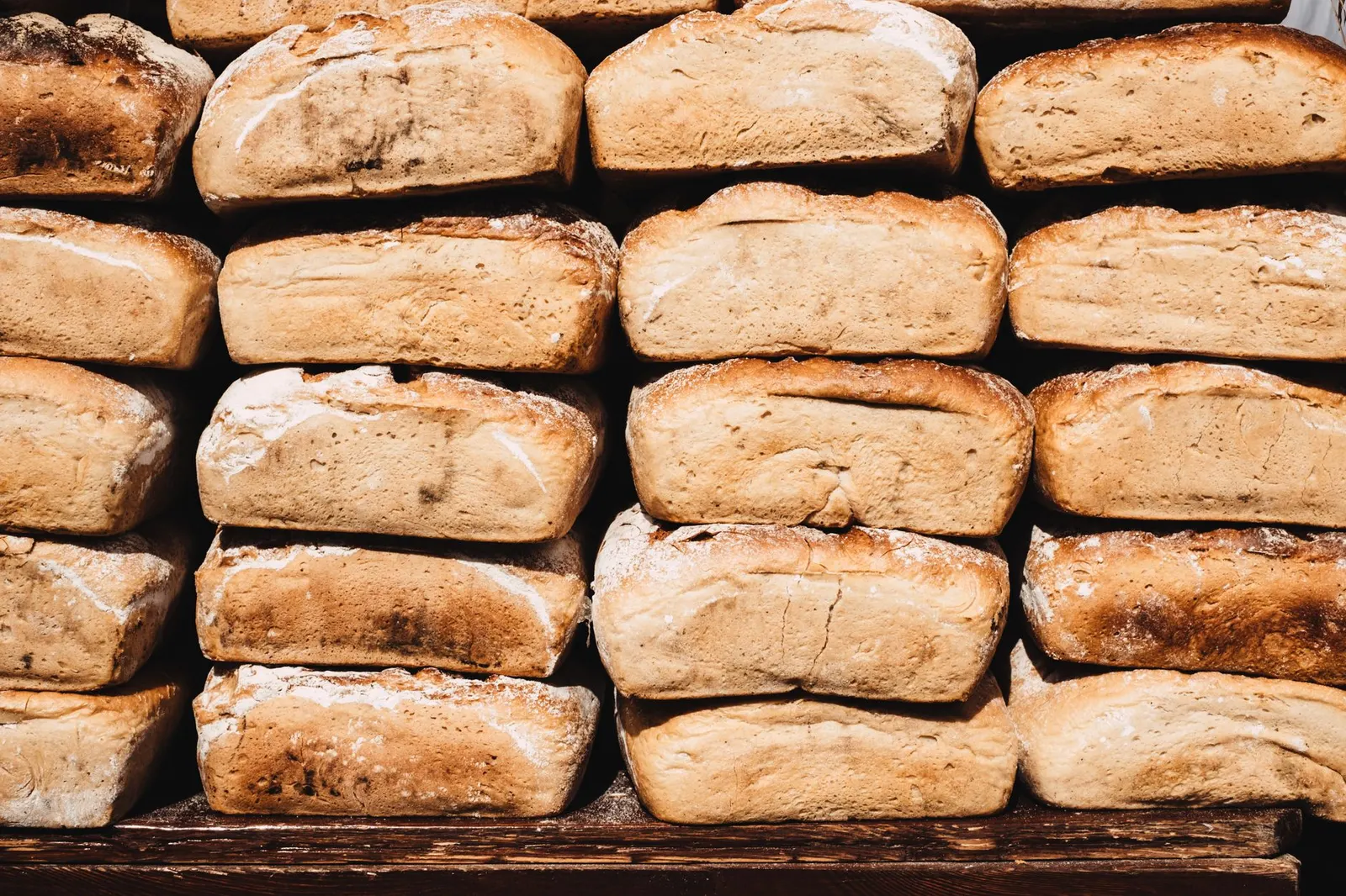 Miches de pain rustique fraichement cuites sur une planche en bois